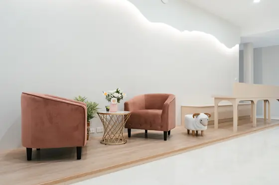 Lobby reading corner with two velvet armchairs, flowers and a sheep-shaped stool