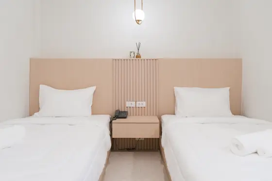 Two single beds against a blonde wood headboard in a Superior Twin