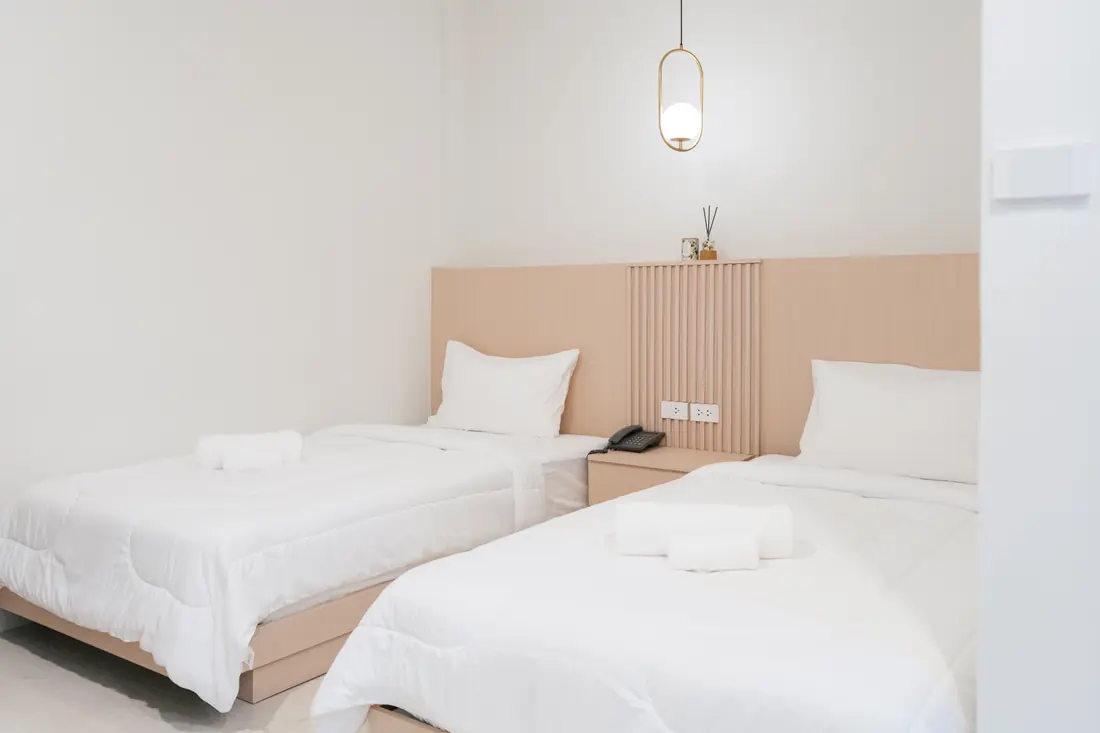 Superior Twin room with two single beds, a shared bedside table and a brass pendant lamp