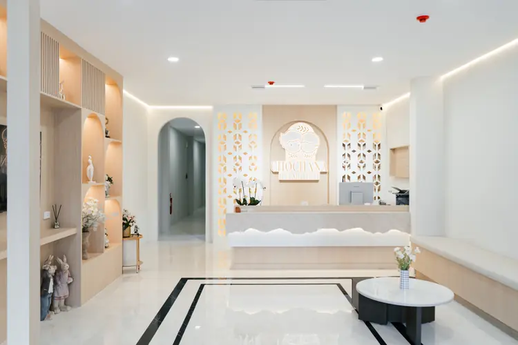 The lobby at Chochana Hometel with arched wooden shelves, white marble floor and the reception desk